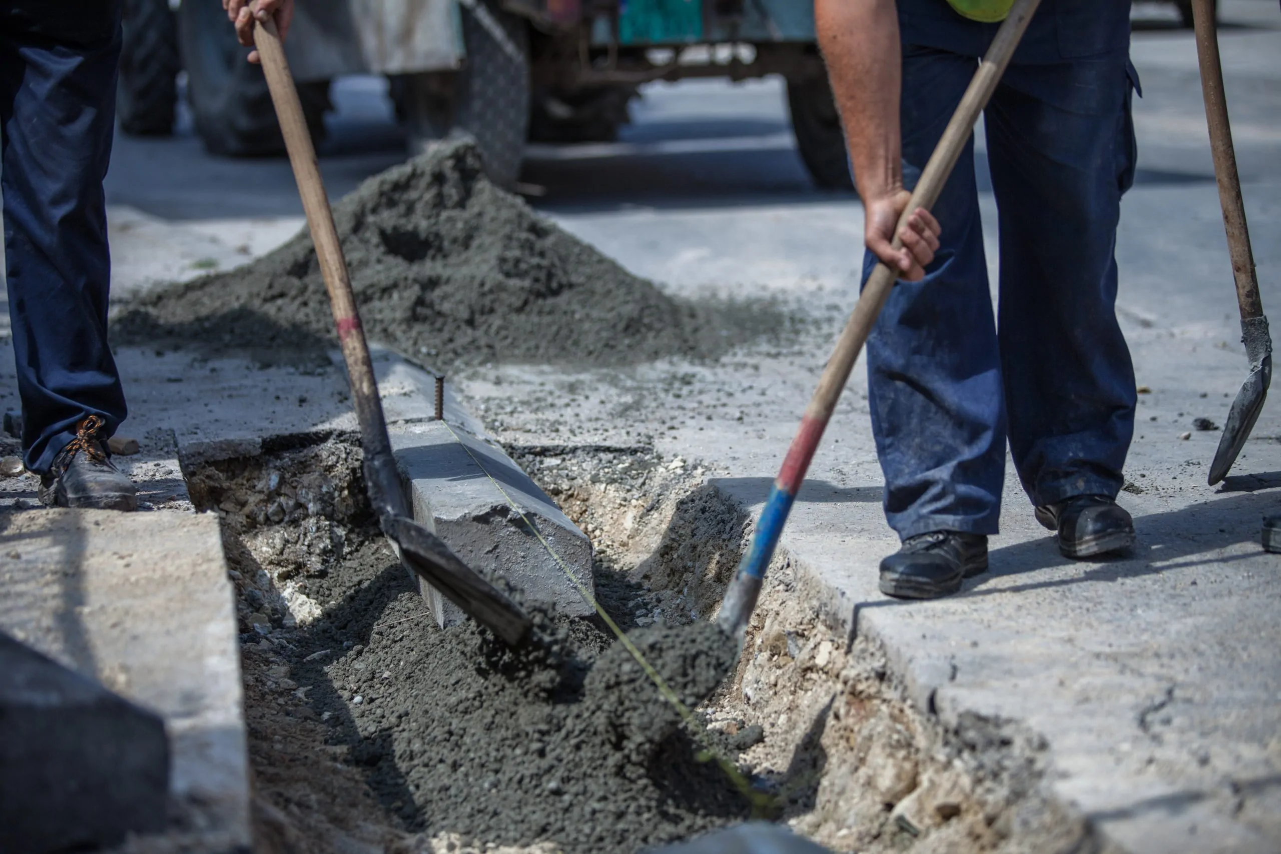 Workers filling the hole with cement for installing fibre optic cables